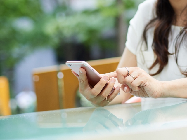 スマホを持つ女性の手