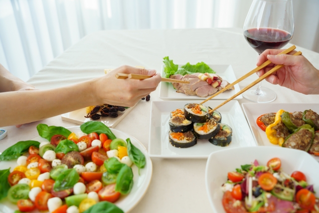 食卓の料理に手を伸ばす箸